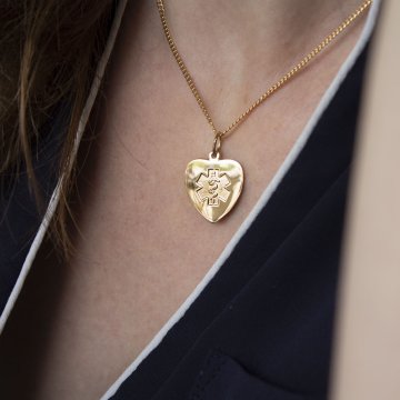 Heart-shaped gold pendant with embossed medical emblem
